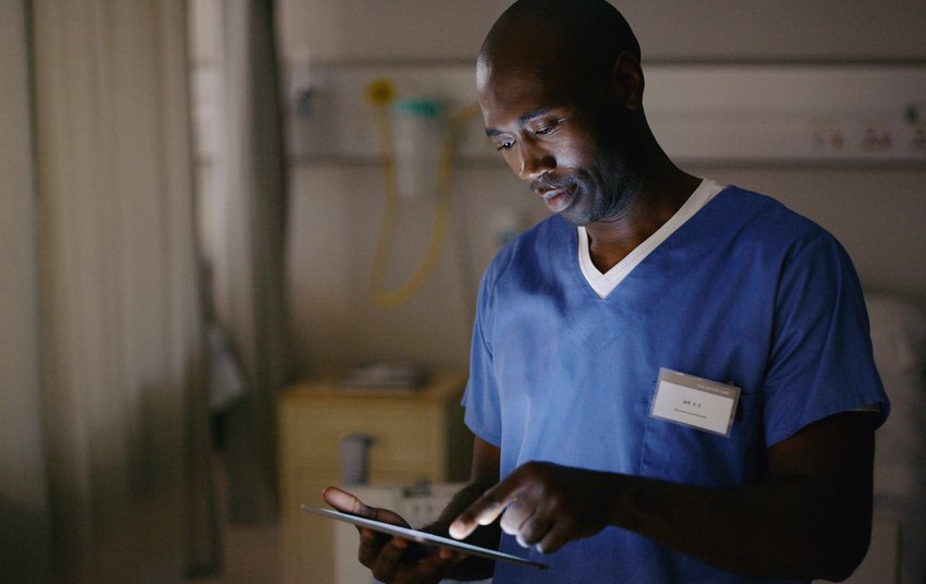 Professionnel de santé se servant d'une tablette numérique pour consulter un dossier médical